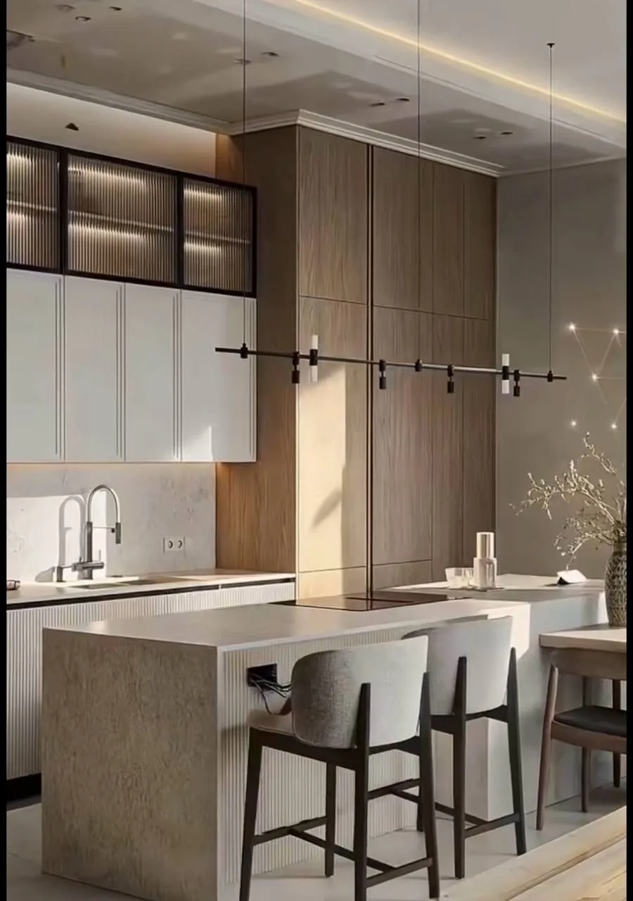 Kitchen island and cabinetry mid-install on bare floor, then finished fluted island, reeded-glass uppers, and stone tops.
