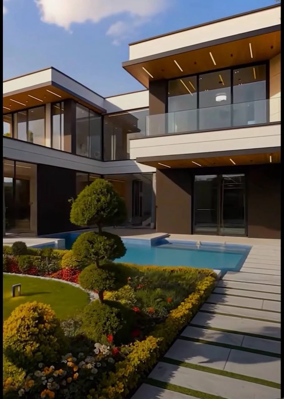 Pool courtyard with scaffolding and bare earth, then finished wood-soffit villa with manicured beds and paver walk.