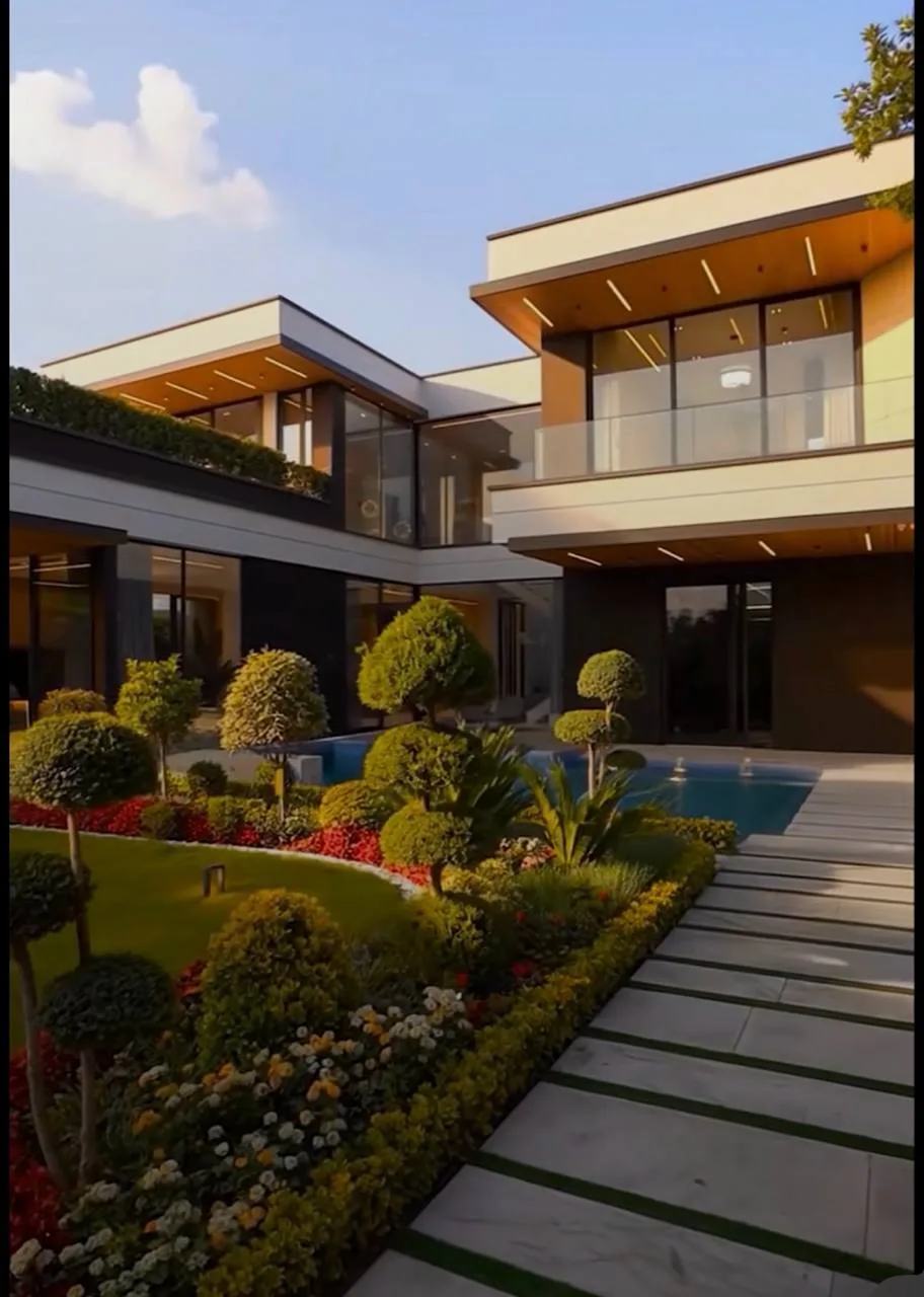 Same modern courtyard during hardscape work, then completed pool edge landscaping and glass facade.