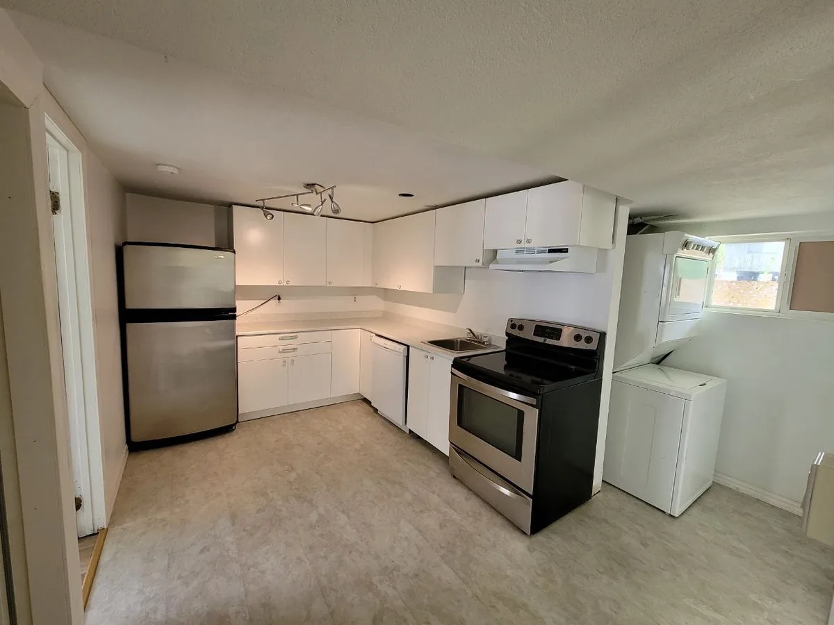 Partition opened to kitchen and laundry during demolition, then finished white kitchen with stacked laundry.