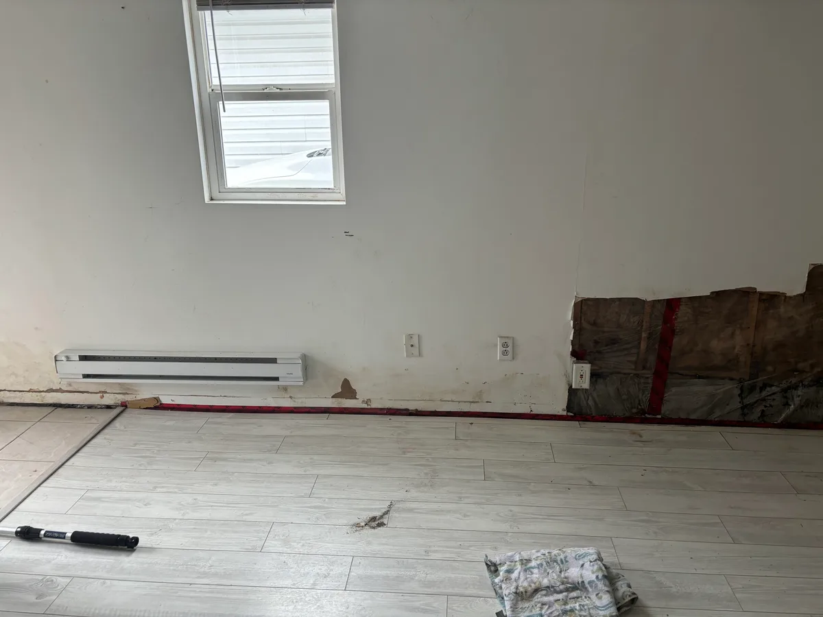 Metro Vancouver Interior: Flooring, Kitchen & Bath — before — Same light plank floor during wall remediation, then finished bedroom with white closet doors.