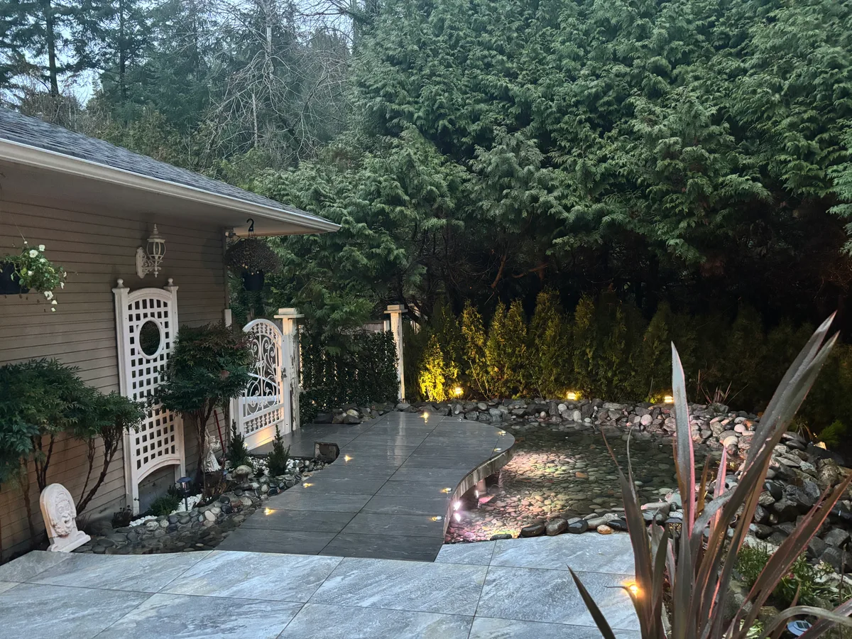 Same side rockery and walkway unfinished, then completed path toward the pond with trellis and hedge backdrop.