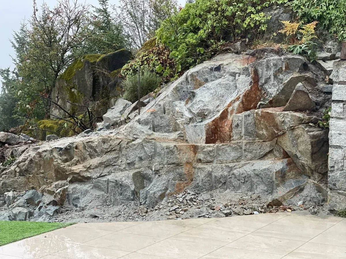 West Vancouver Garden Pond, Paths & Night Lighting — before — Close rock-wall assembly stage, then finished stone walkway and rock bed against the cedar hedge.